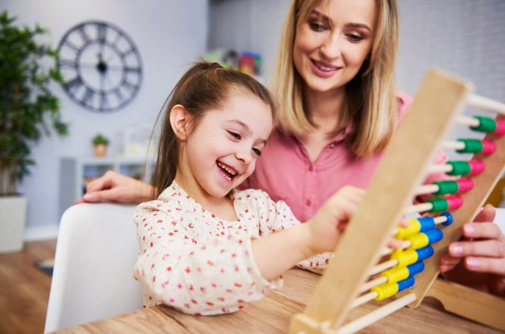 A mother and daughter enjoy learning with an abacus at home